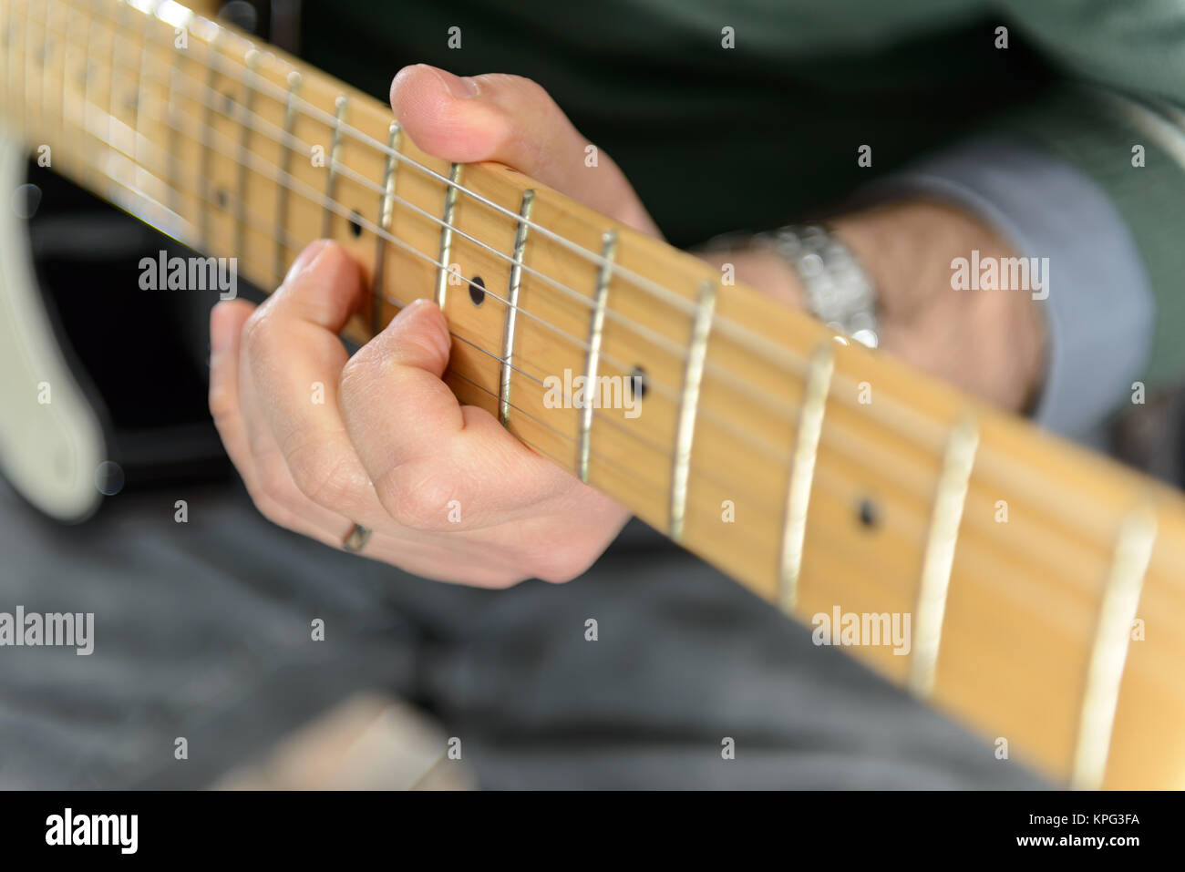 Detail of an electric guitar. Hands moving on the keyboard. Close up. Particularly small and out of focus. Stock Photo