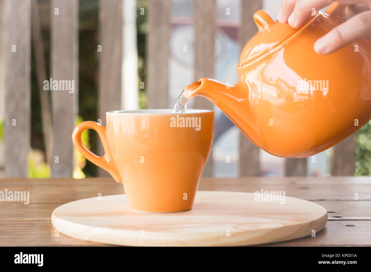 Hot tea is poured from teapot into a cup Stock Photo Alamy