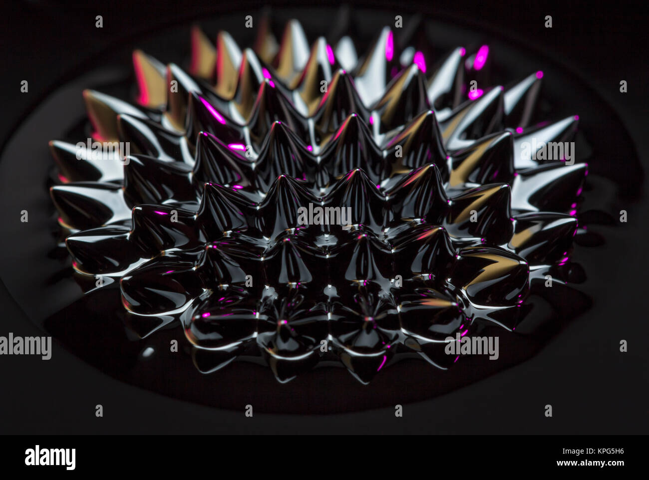 Ferrofluid spikes induced by a neodym magnet Stock Photo