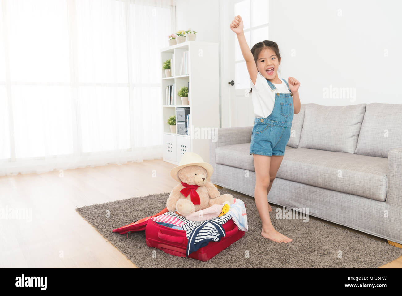 cheerful cute little girl finished packing personal luggage suitcase in