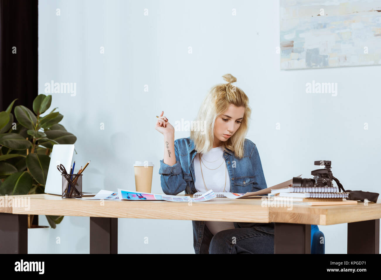 portrait of thoughtful photographer looking at photoshoot examples at