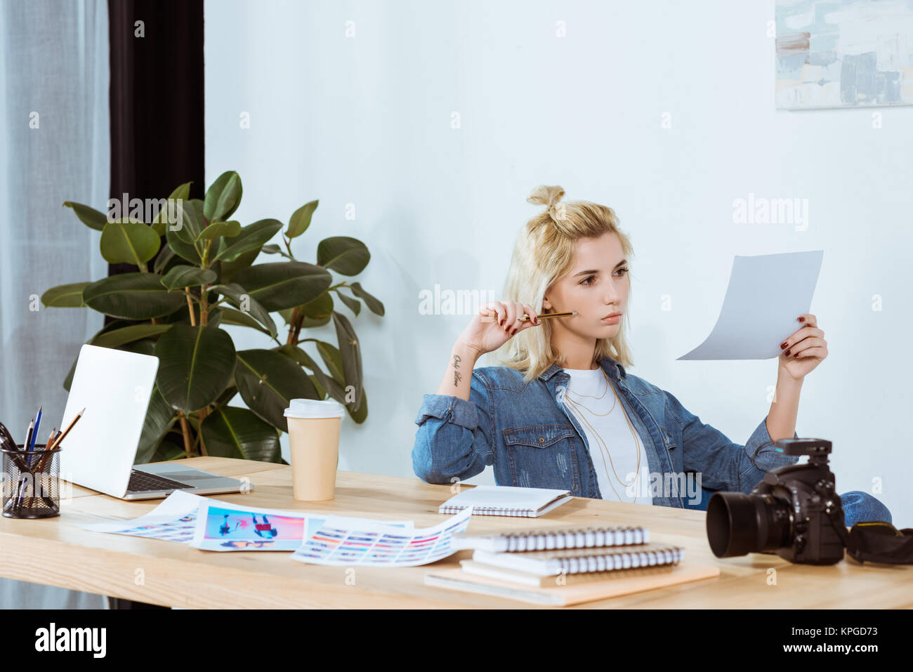 portrait of thoughtful photographer looking at photoshoot examples at