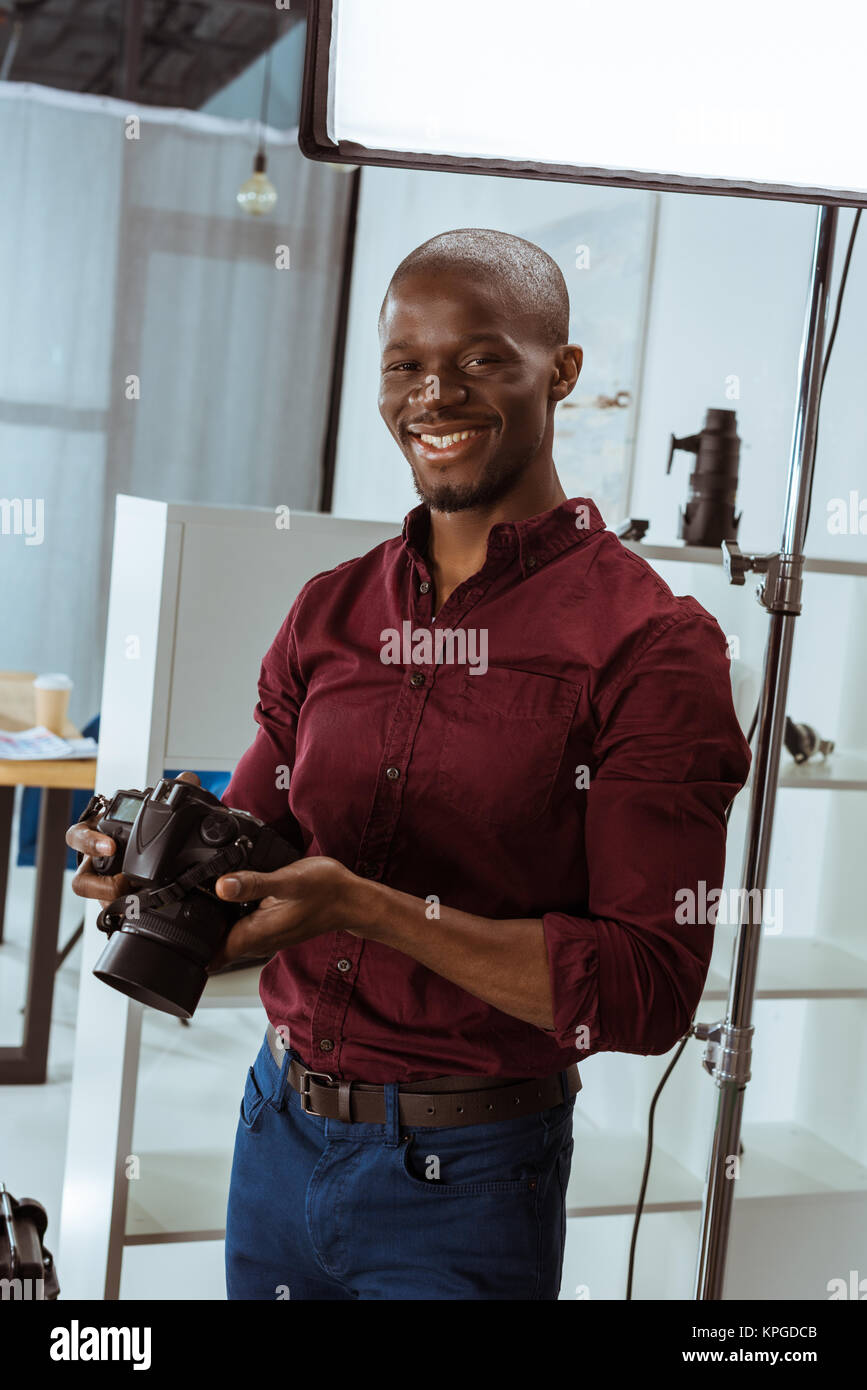 portrait of cheerful african american photographer with photo camera in ...