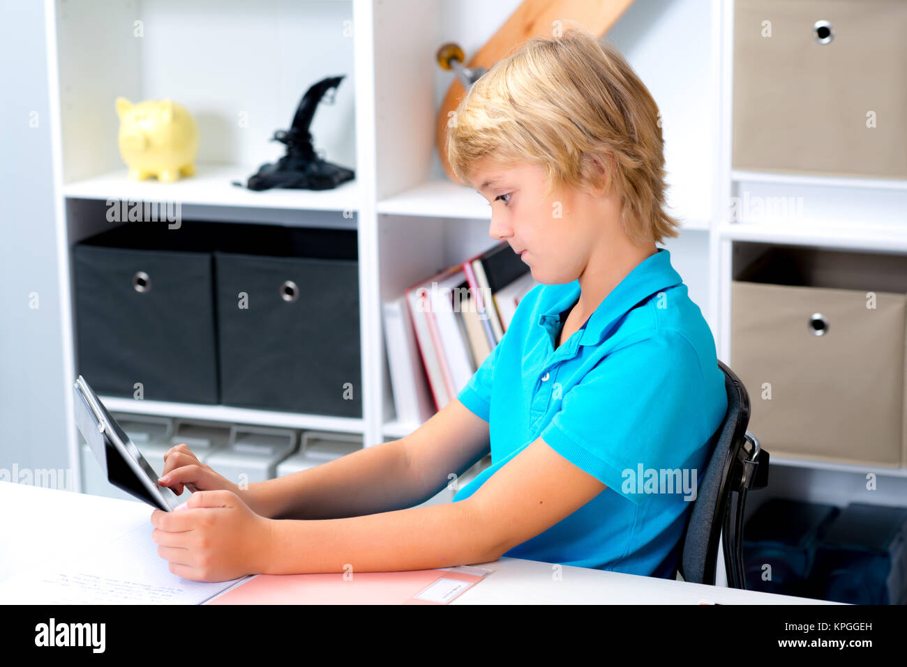 blond boy using tablet computer in his room Stock Photo - Alamy