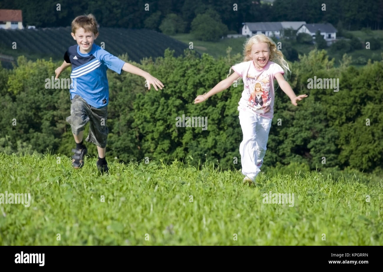 Kinder laufen in der Wiese - kids running in meadow Stock Photo