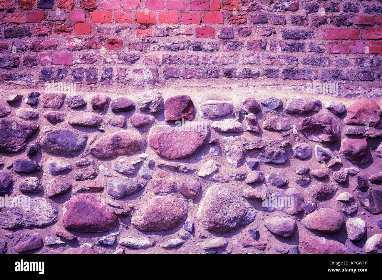 Old brick and stone wall, Ultra Violet color toned image. Stock Photo
