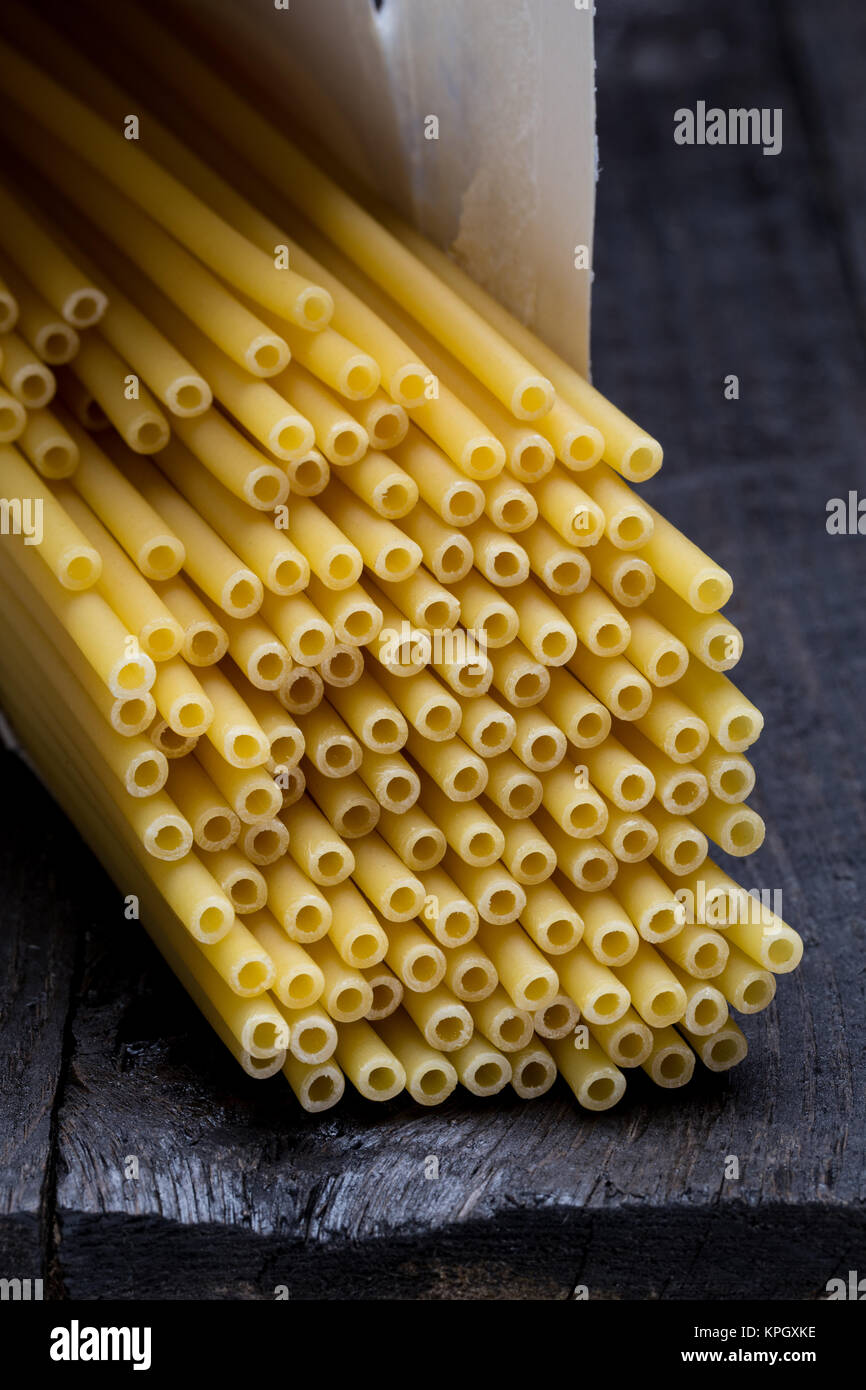 Macaroni pasta on dark rustic wood. Stock Photo