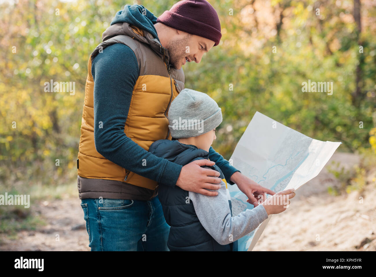 Father and son hiking in forest. Looking at map Stock Photo - Alamy