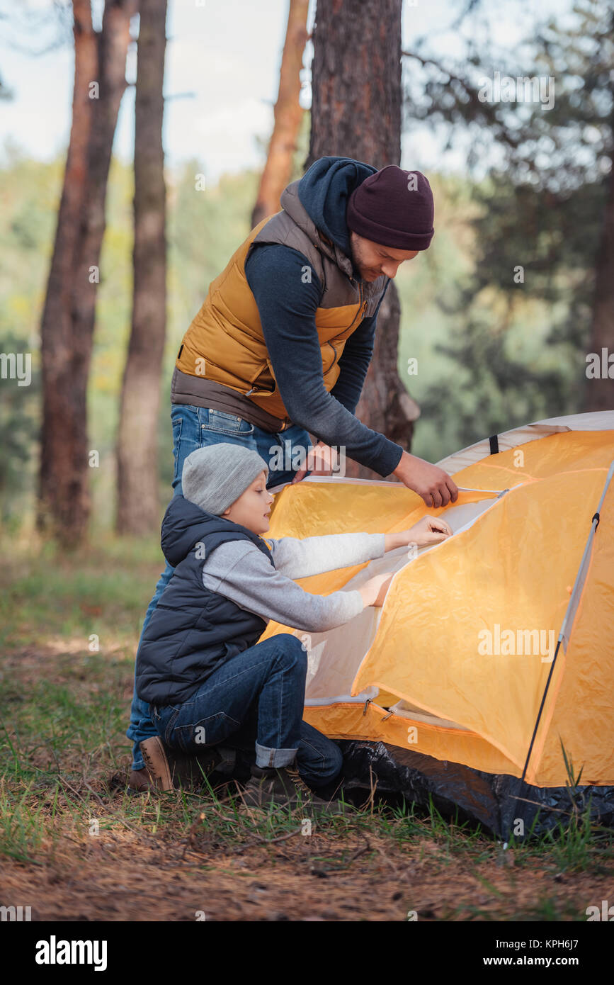 father and son putting up tent Stock Photo