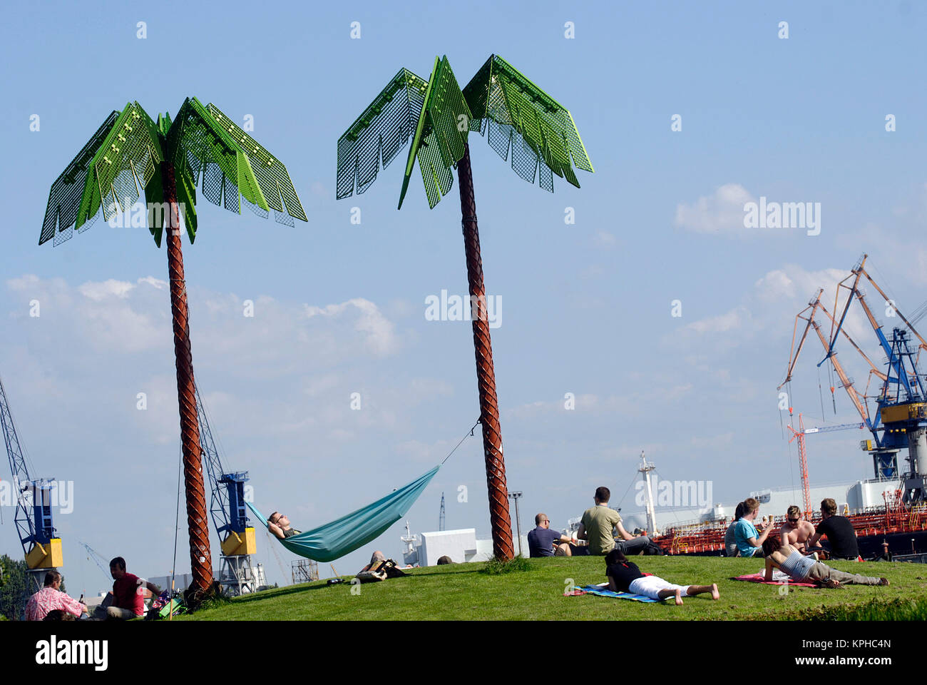 Relaxed man with hammock between artificial palms. Park Fiction, Hamburg St. Pauli. Summer in the City, Hamburg kann so schön sein Stock Photo