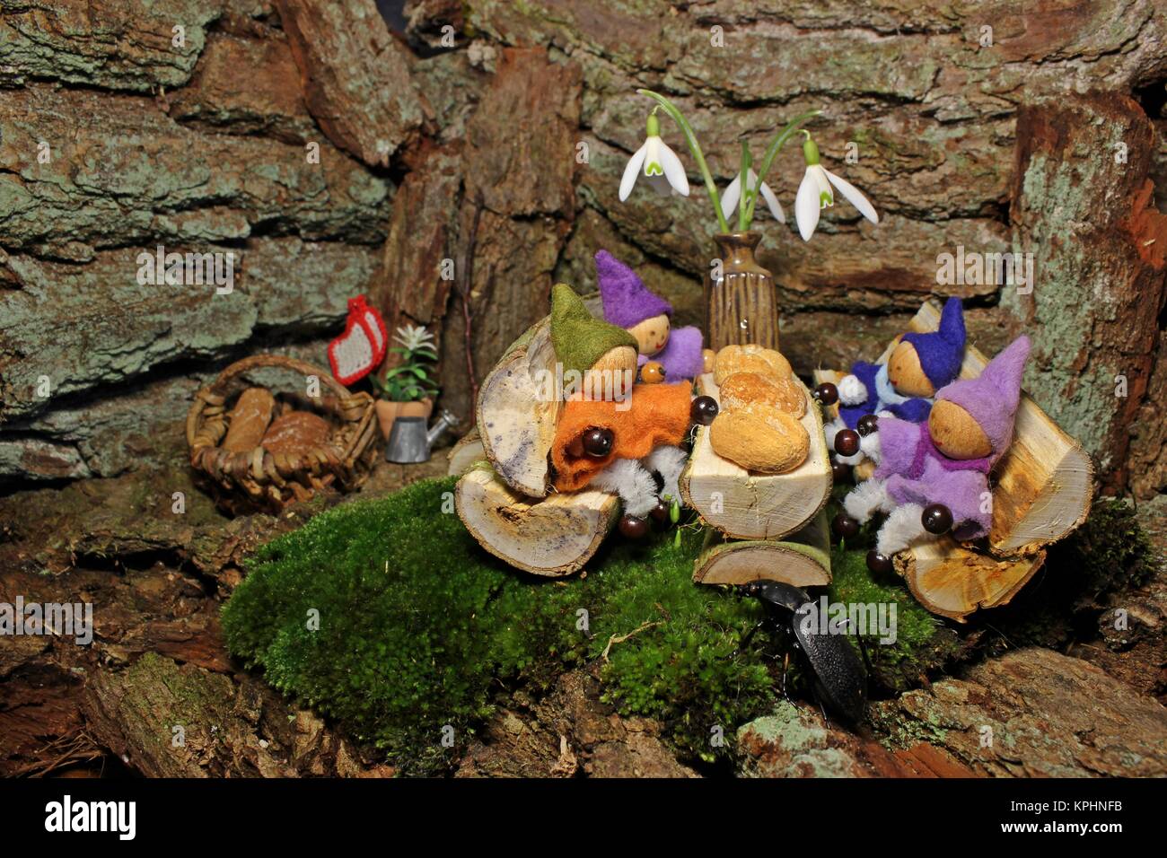 four little gnomes at breakfast with beetle Stock Photo