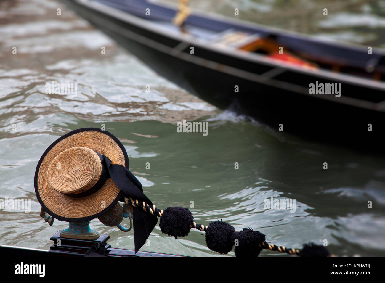 Europe, Italy, Venice. Gondolier Hat and Passing Gondola Stock Photo
