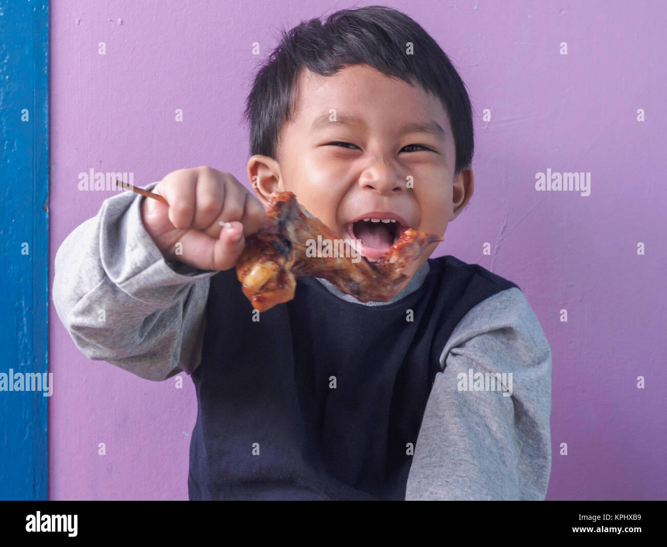 asian boy eating roasted chicken wing Stock Photo Alamy