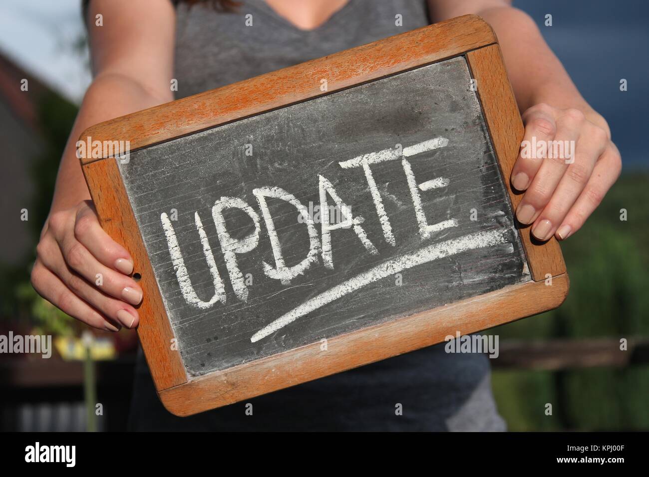Update One Written UPDATE written with chalk on slate shown by young female Stock Photo ...