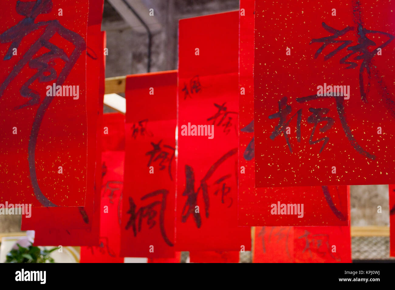 Red pennant flags hanging on ropes with Chinese calligraphy character ...