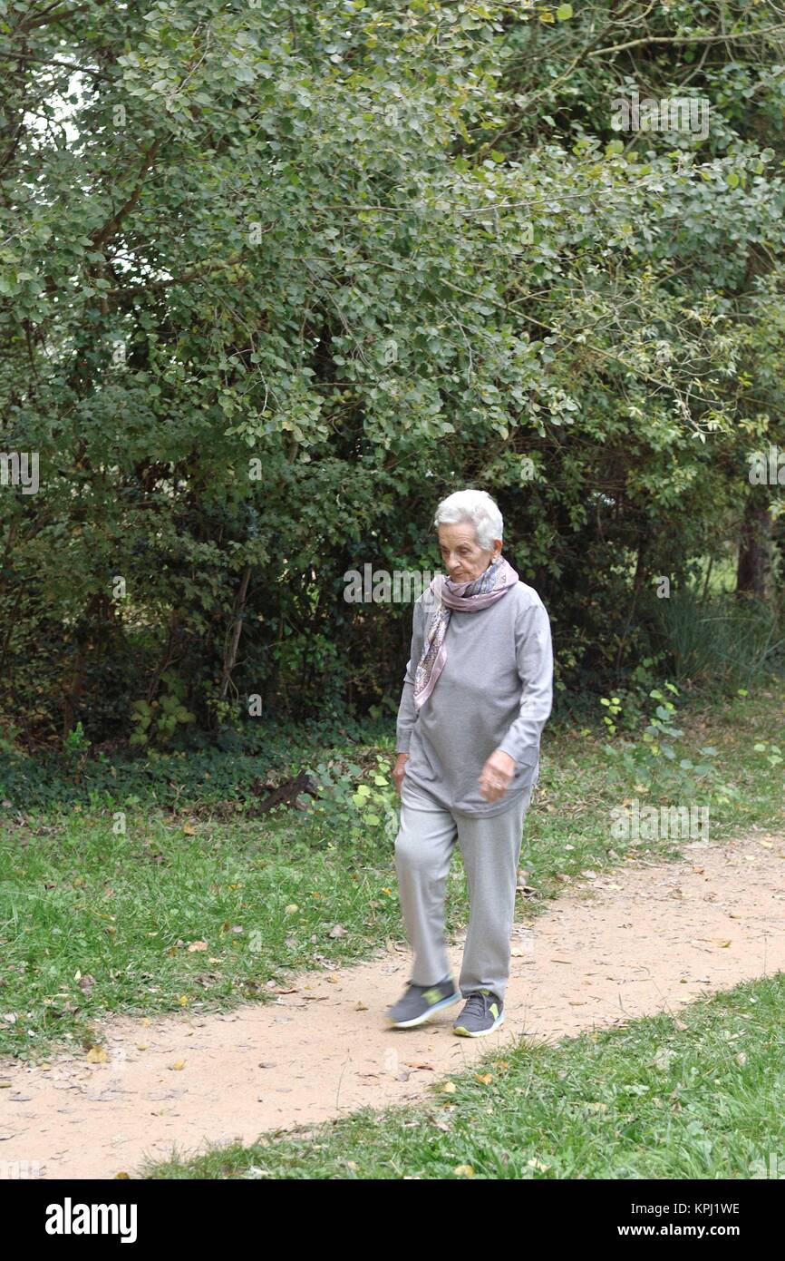 old woman walking in a park Stock Photo - Alamy