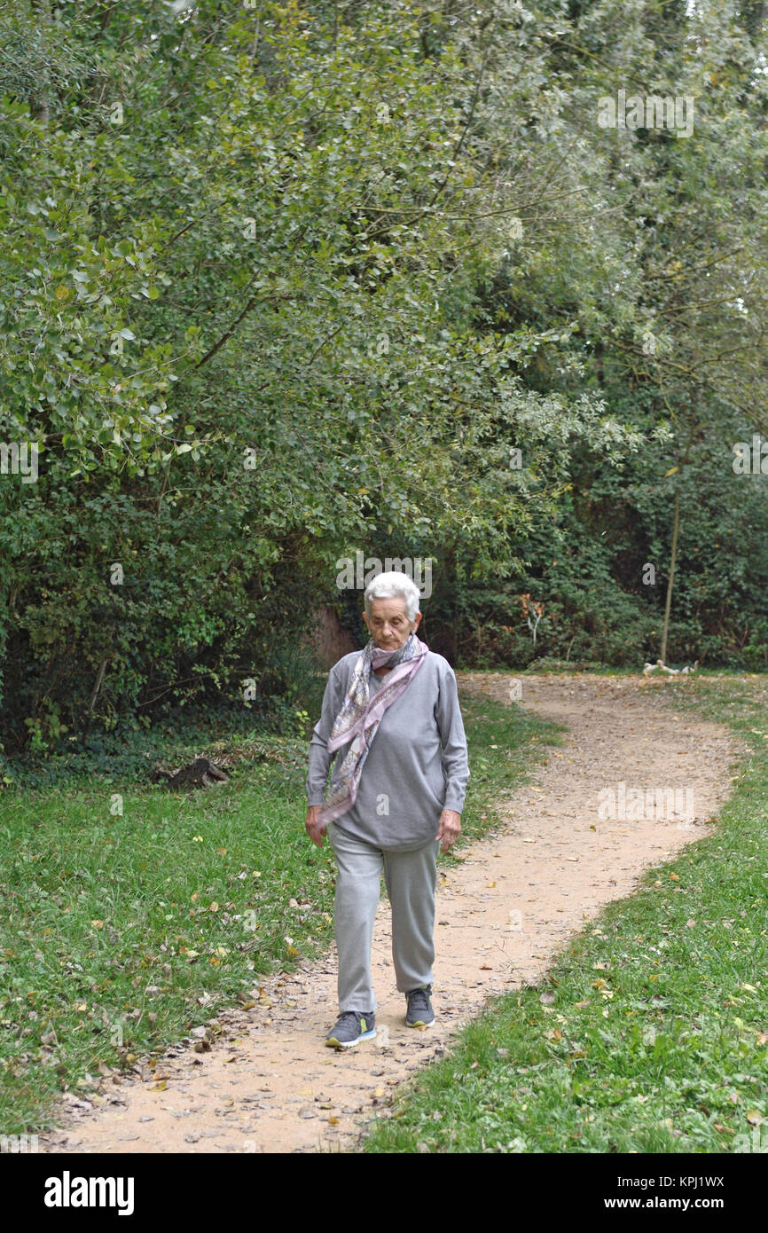 old woman walking in a park Stock Photo - Alamy
