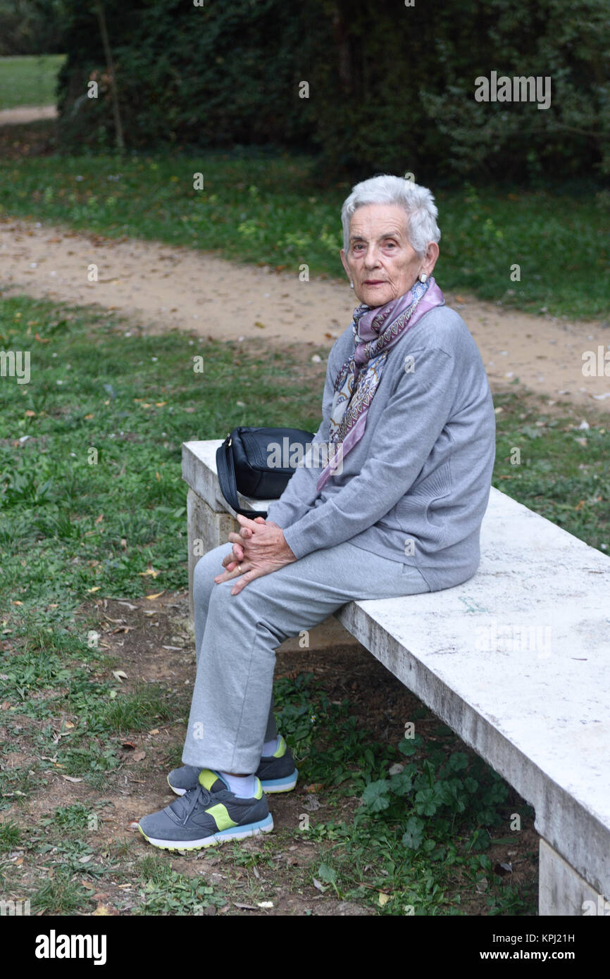 Senior citizen sitting on a park bench in autumn hi-res stock ...