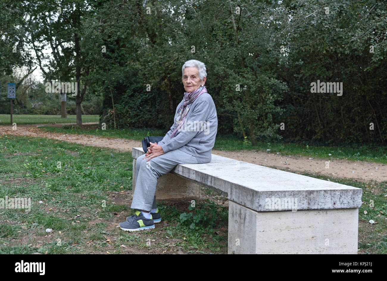 senior woman sitting alone on a bench in a park Stock Photo - Alamy