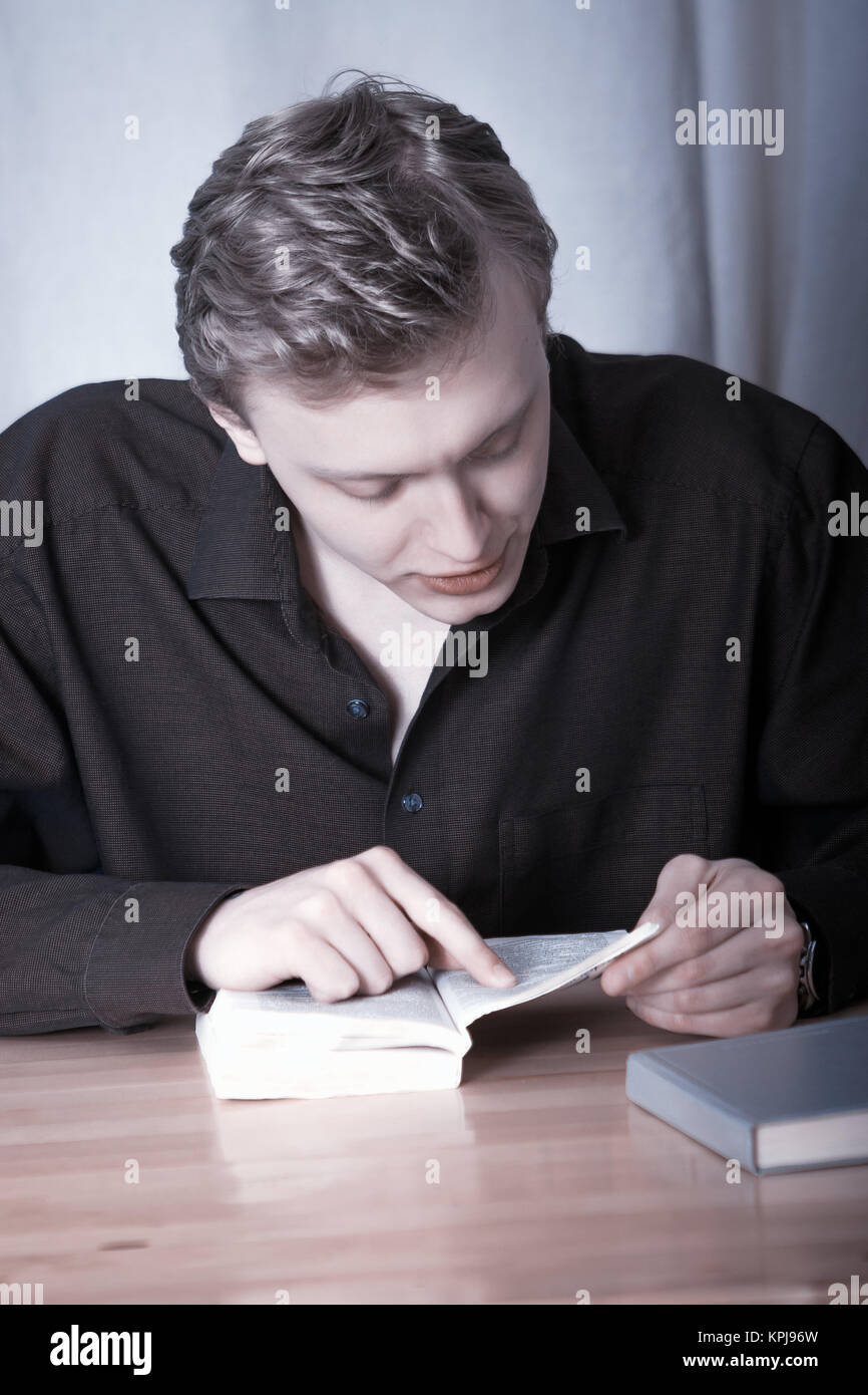 The young man bent over the book Stock Photo