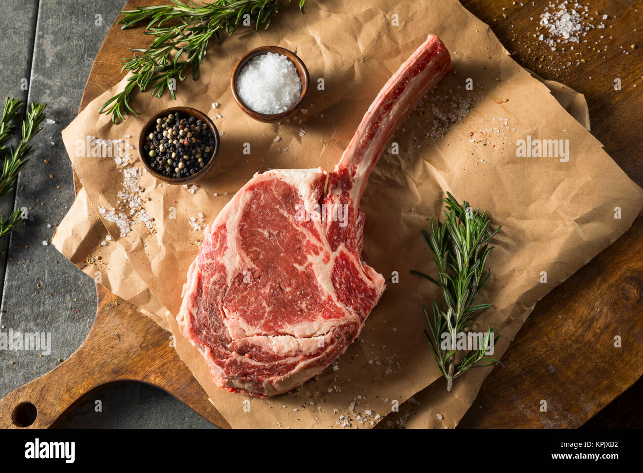 Raw Red Grass Fed Tomahawk Steaks with Rosemary Stock Photo