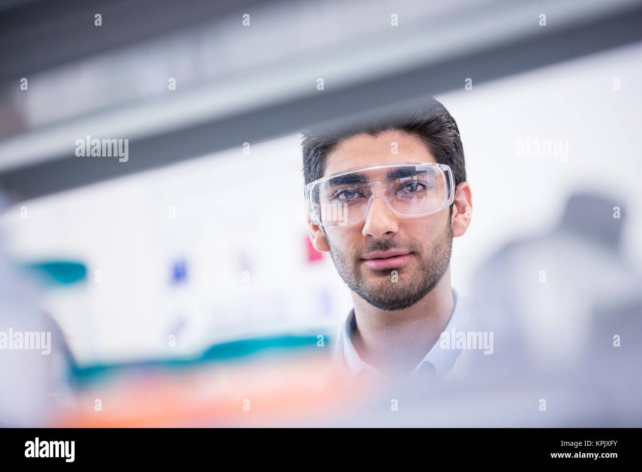 Male laboratory assistant wearing safety goggles. Stock Photo