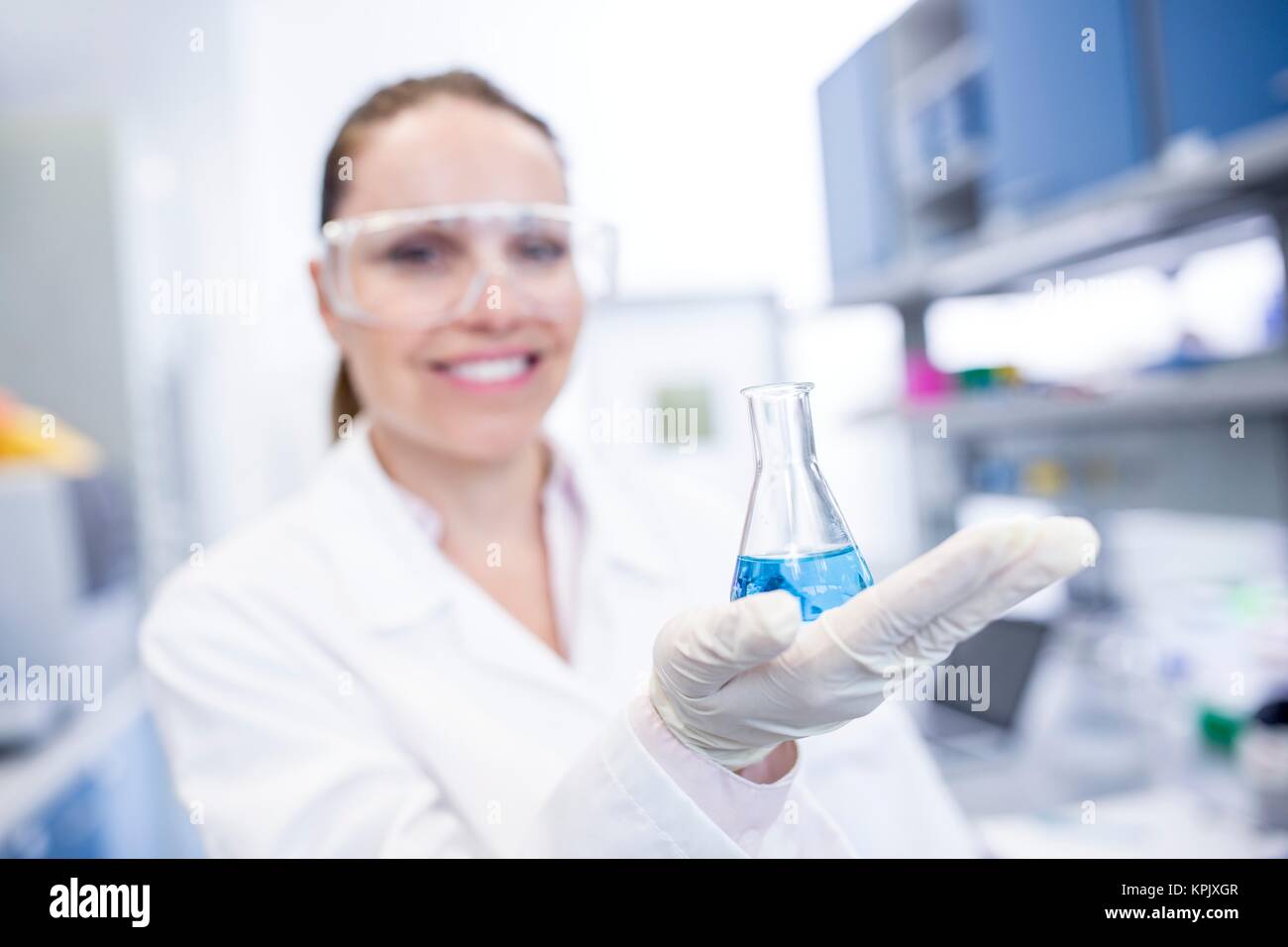 Female laboratory assistant holding chemical flask. Stock Photo