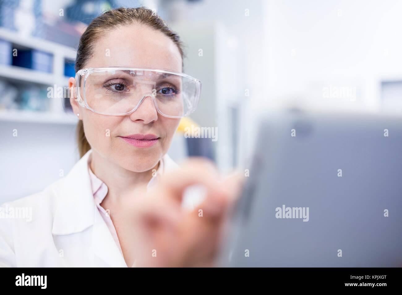 Female laboratory assistant using tablet. Stock Photo