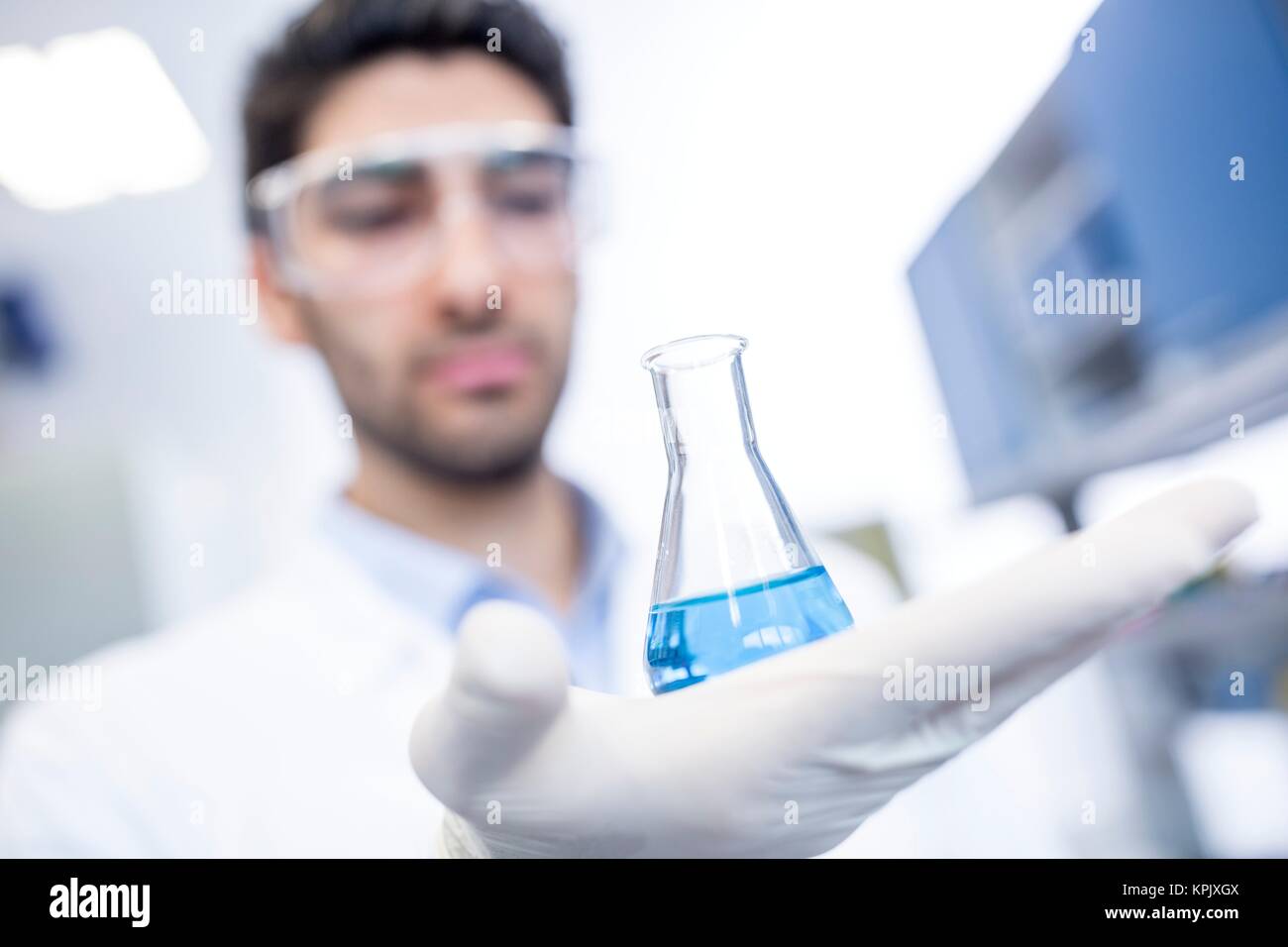 Male laboratory assistant holding chemical flask. Stock Photo