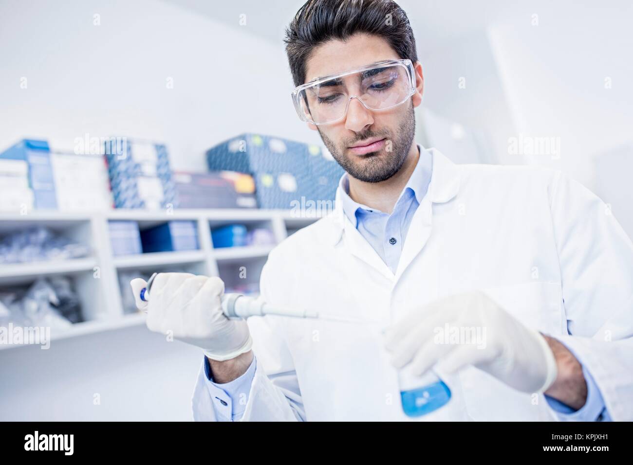 Male laboratory assistant using pipette. Stock Photo