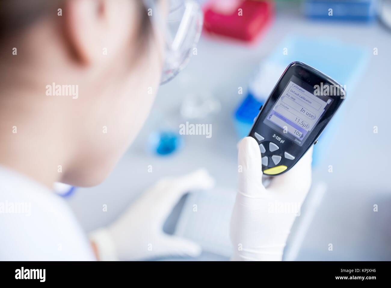 Laboratory assistant using electronic pipette. Stock Photo