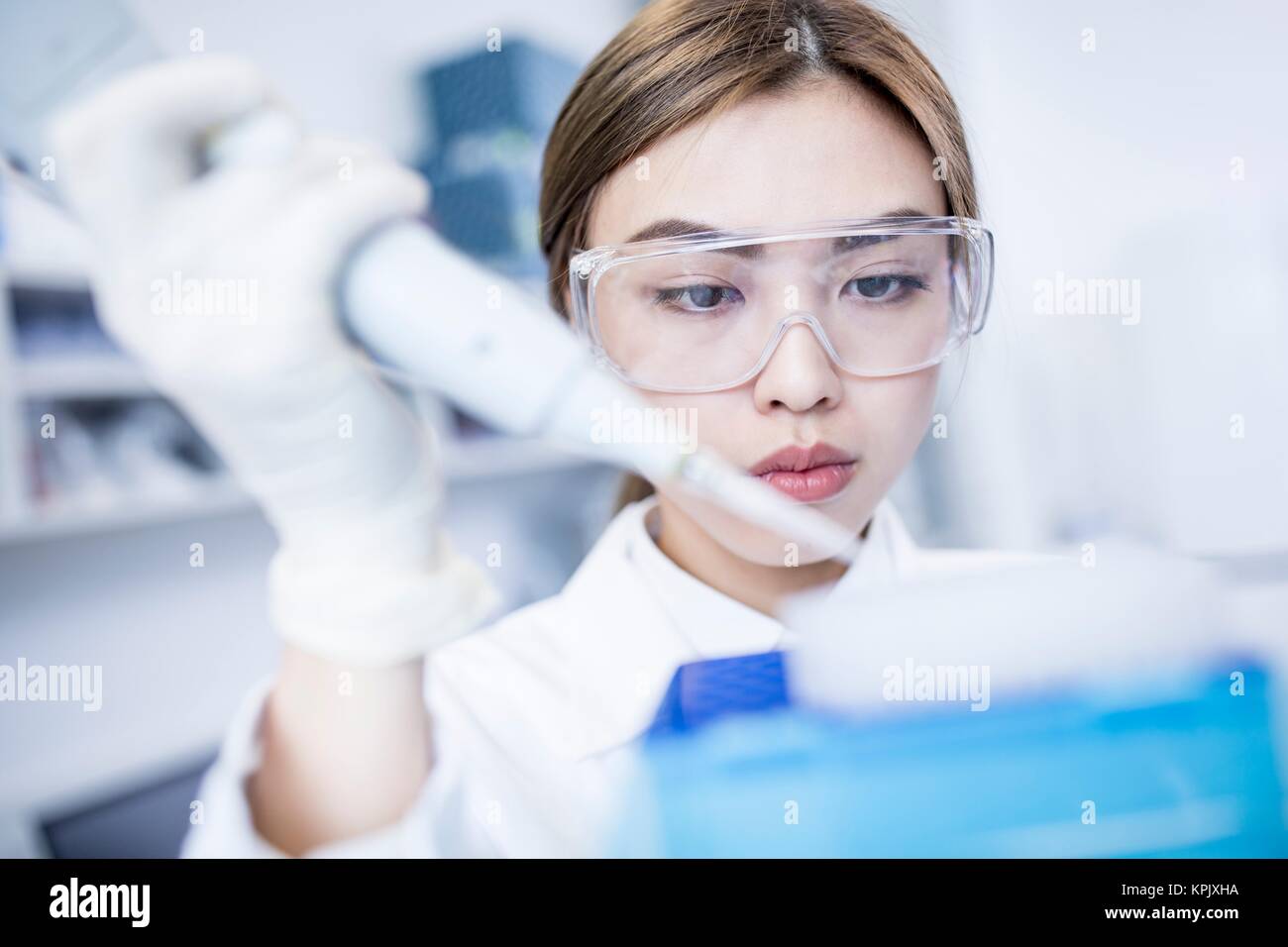 Female laboratory assistant using pipette. Stock Photo