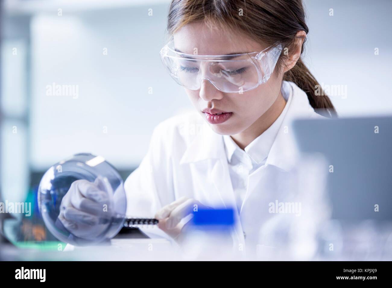Female laboratory assistant using equipment. Stock Photo