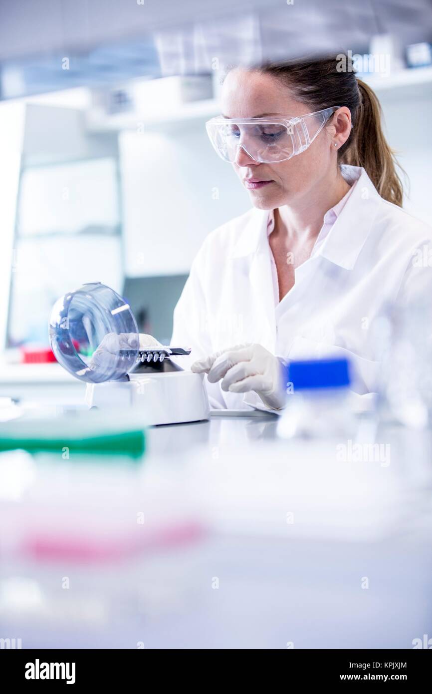 Female laboratory assistant using mini centrifuge. Stock Photo