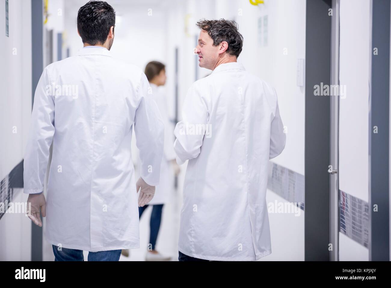 Male doctors walking down corridor. Stock Photo