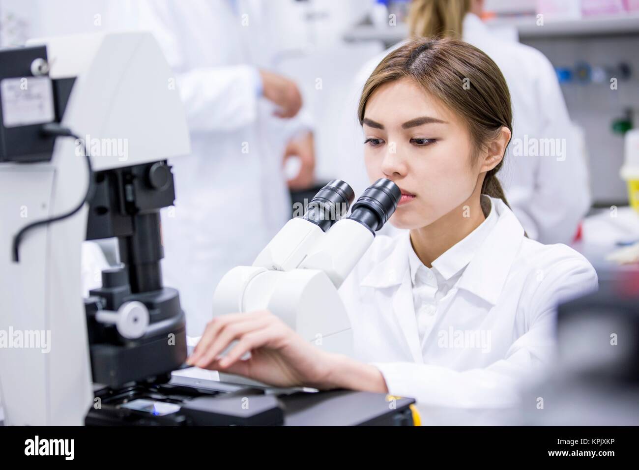 Female scientist using microscope in laboratory. Stock Photo