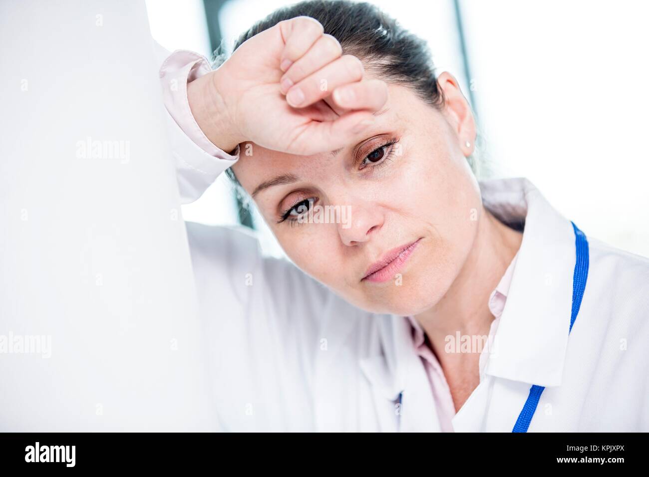 Young female medical student with head in hands. Stock Photo
