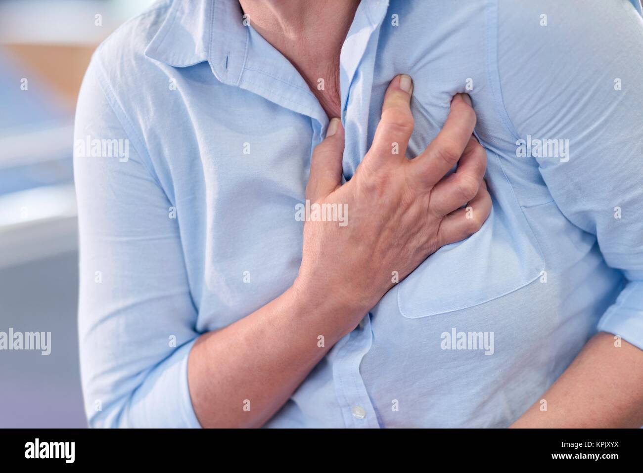 Woman clutching her chest, cropped view. Stock Photo