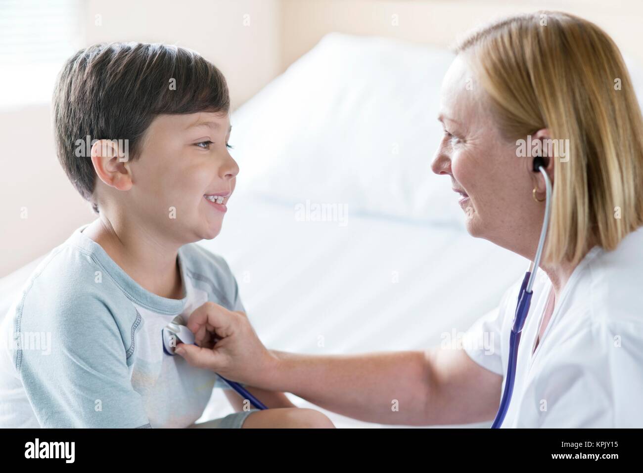 Young boy smiling towards nurse with stethoscope. Stock Photo