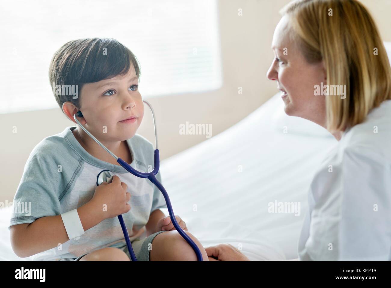 Young boy wearing stethoscope with nurse. Stock Photo