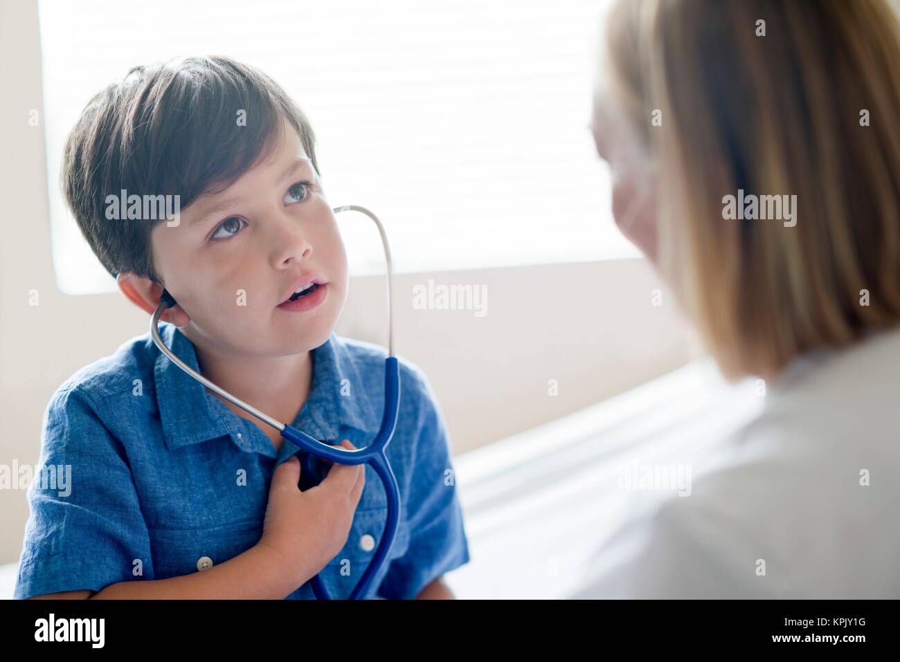 Young boy wearing stethoscope with nurse. Stock Photo