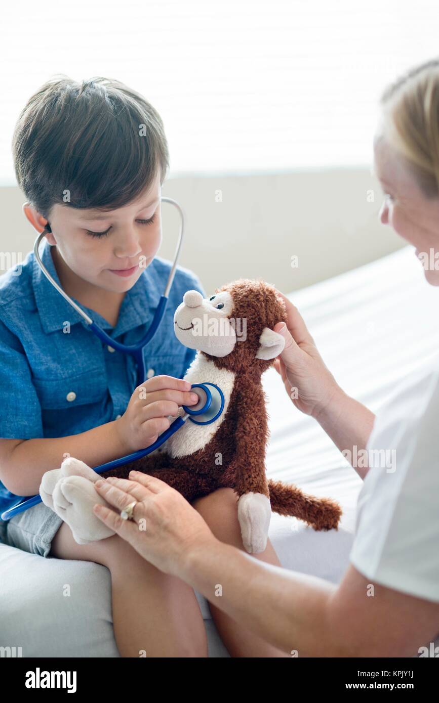 Young boy playing with stethoscope and teddy bear. Stock Photo
