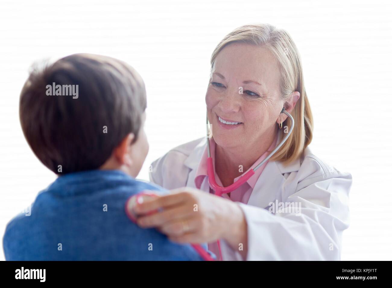 Nurse using stethoscope with young boy. Stock Photo