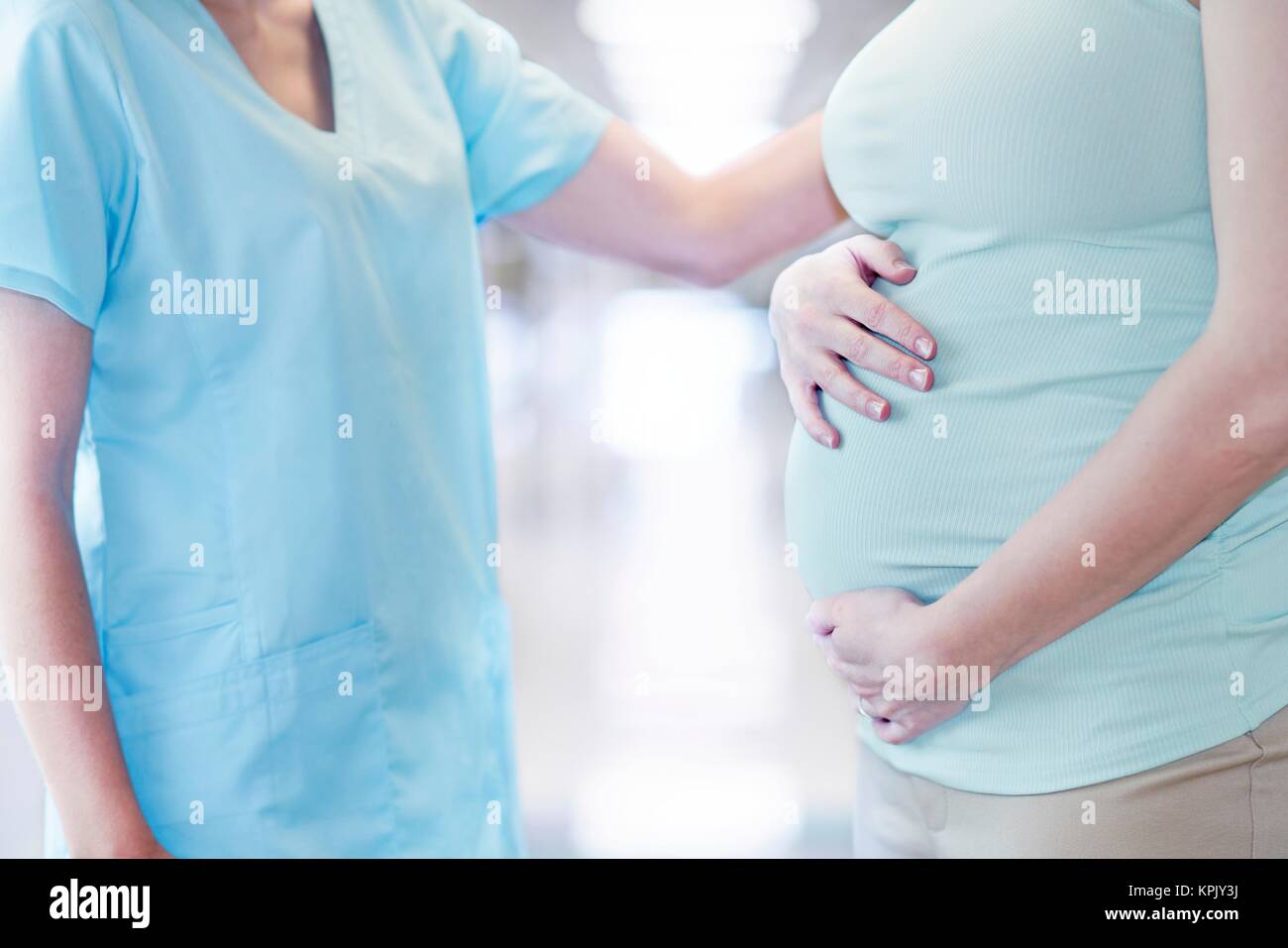 Pregnant woman with nurse, cropped view. Stock Photo