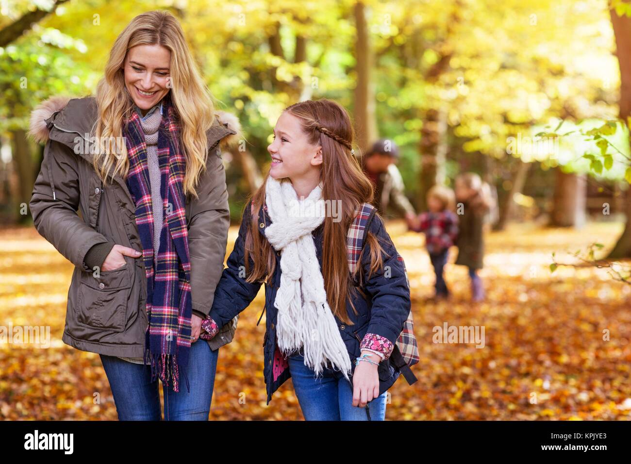 Mother walking through woods with her daughter. Stock Photo