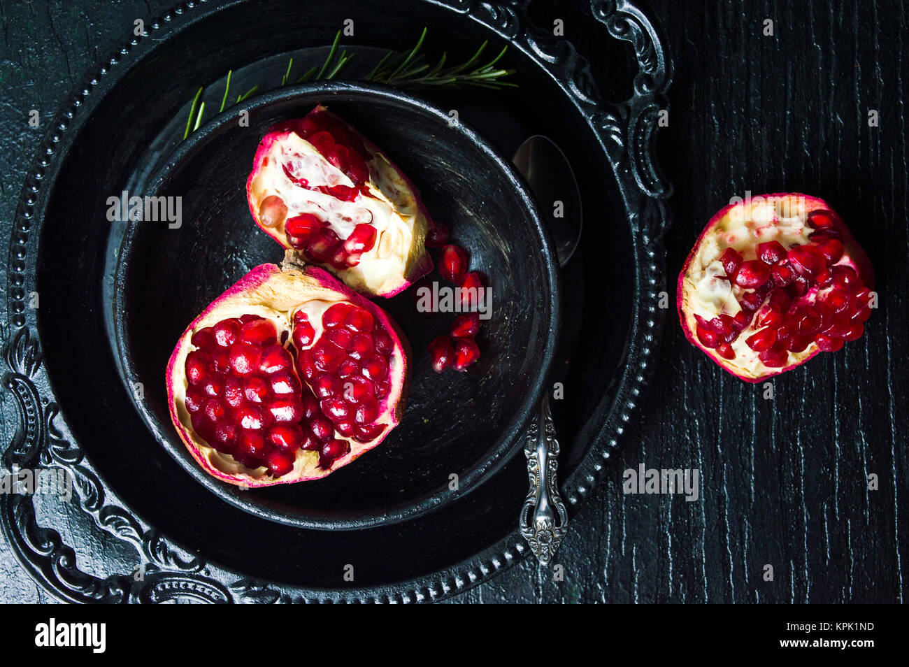 Pomegranate fruit on black plate and dark table Stock Photo