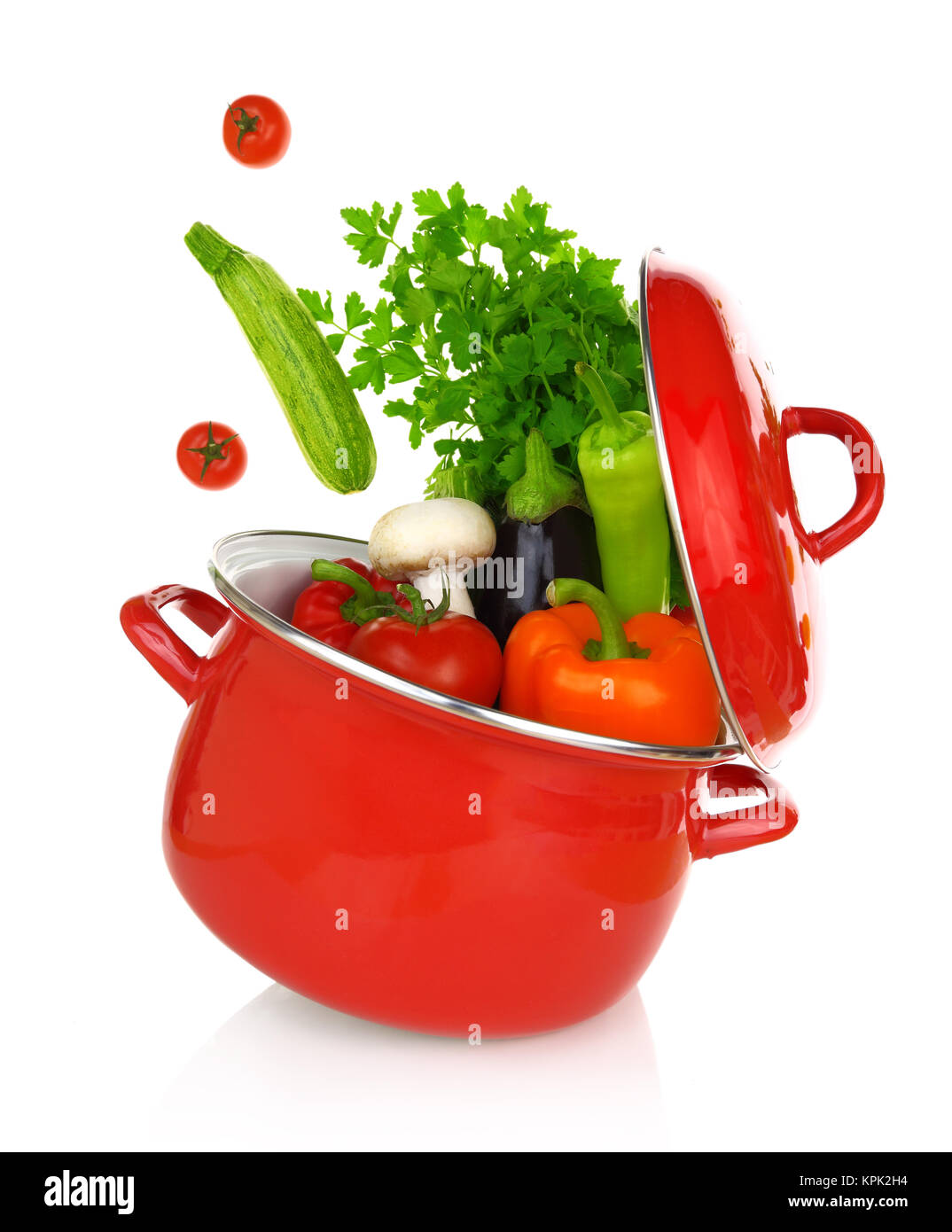 Colorful vegetables coming of a red cooking pot Stock Photo