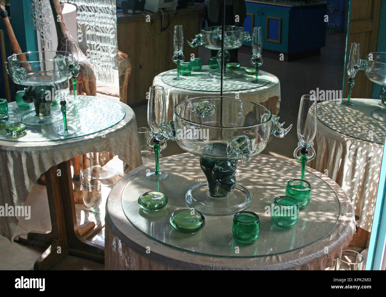 Round tables displays with all sorts of green glasses handmade from recycled glass for sale, Kingdom of Swaziland. Stock Photo