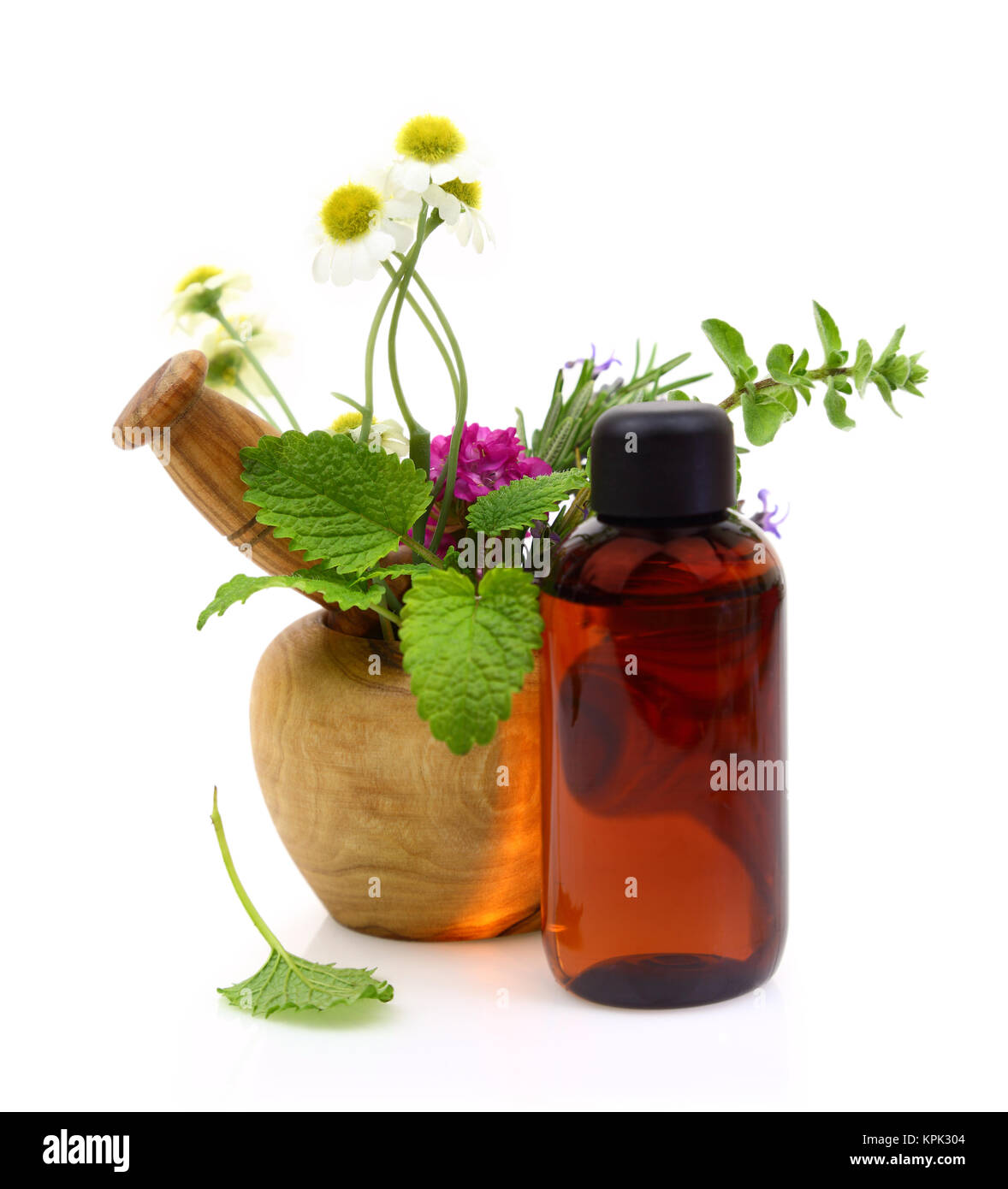 Mortar and pestle with fresh herbs and essential oil bottle Stock Photo