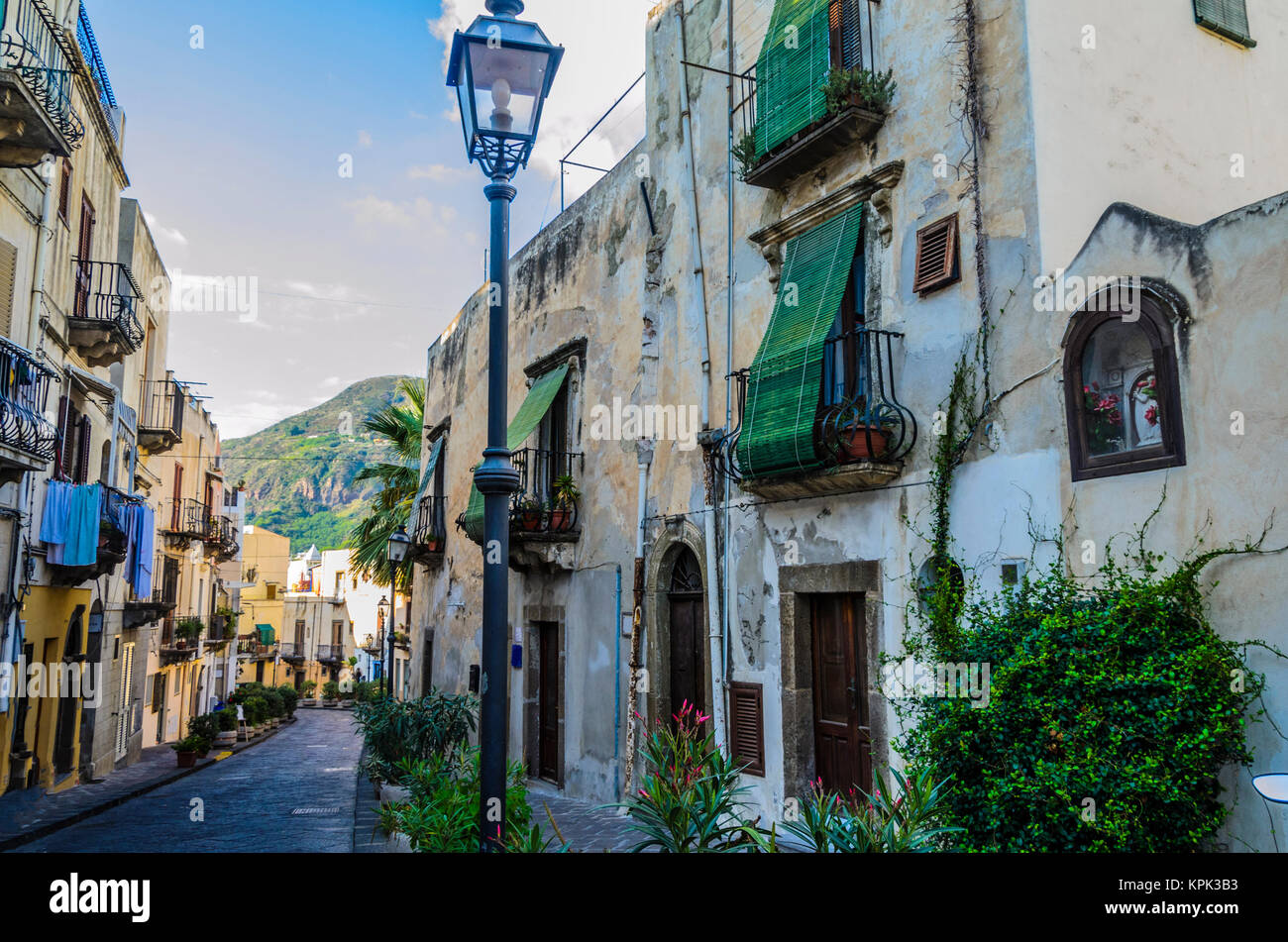 Typical neighborhood street on the island of lipari with its flowering pots and ancient constructions Stock Photo